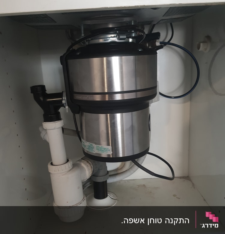 מתקן טוחן אשפה מתחת לכיור עם צינורות חיבור